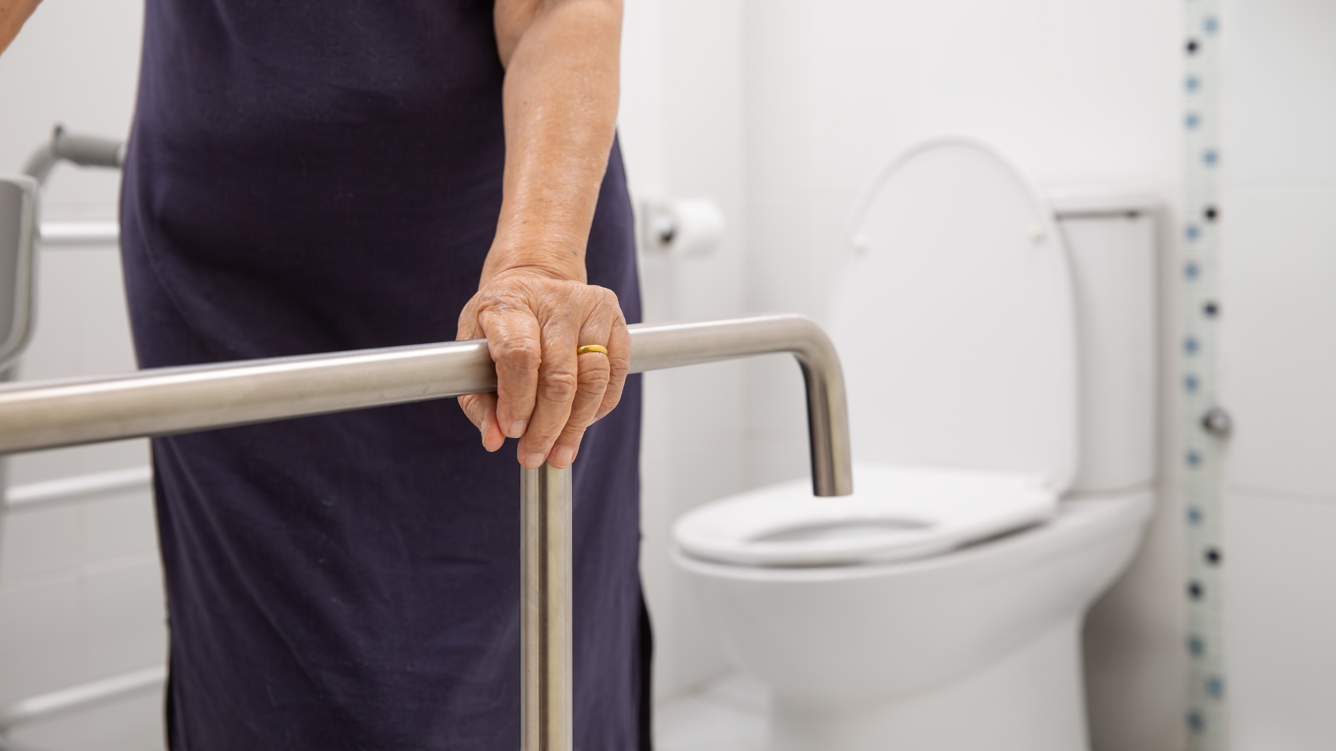 Support rail fitted beside an adapted toilet for independent living
