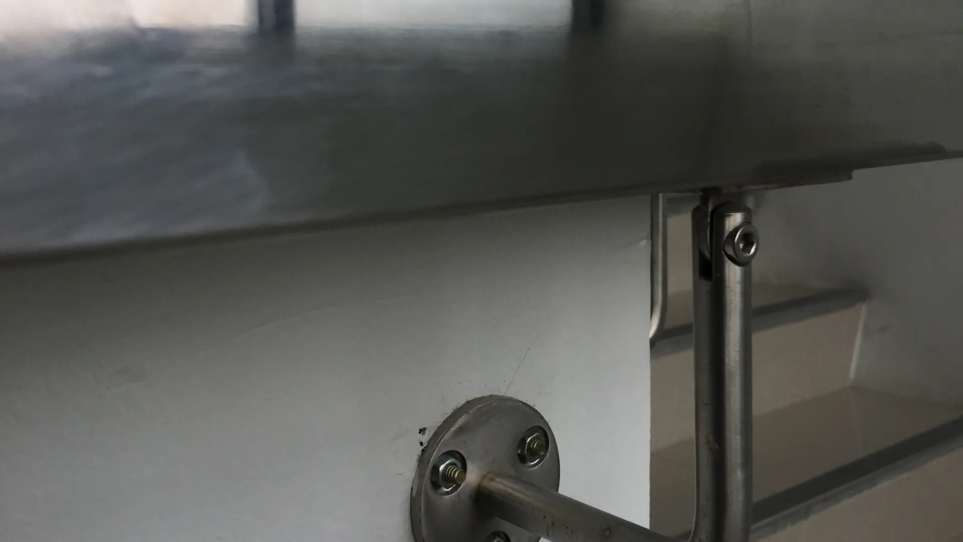 Handrail securely bolted to the wall alongside a domestic staircase